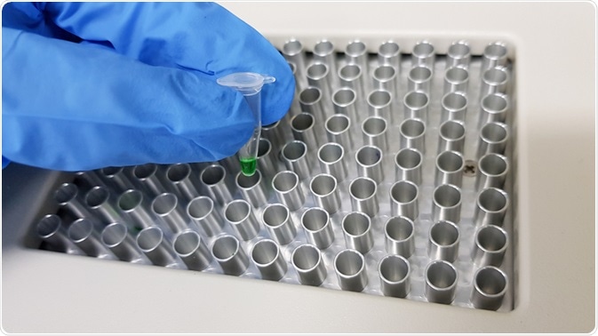 Picture of scientist placing PCR tube with Taq polymerase into PCR machine - taken by Putita Picture of scientist placing PCR tube with Taq polymerase into PCR machine - taken by Putita