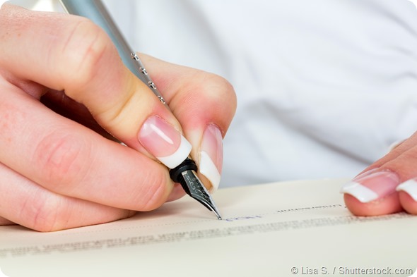 a woman signs a contract or a will with a fountain pen