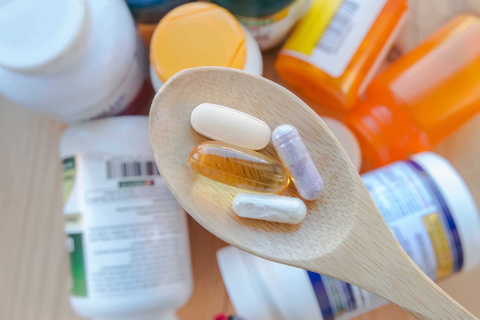 supplements and vitamins are in a wooden spoon